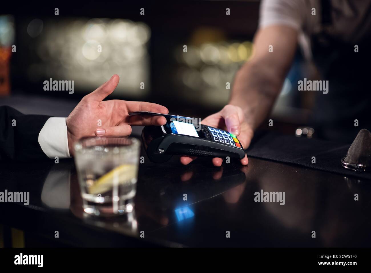 Der Barkeeper akzeptiert die Zahlung per Kreditkarte an der Bar. Stockfoto