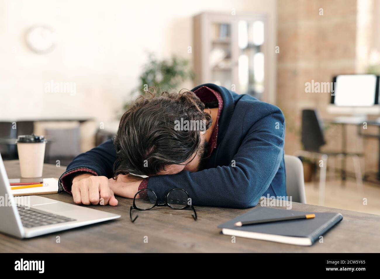 Junge überarbeiteten Geschäftsmann in formalwear nappen vor dem Laptop Stockfoto