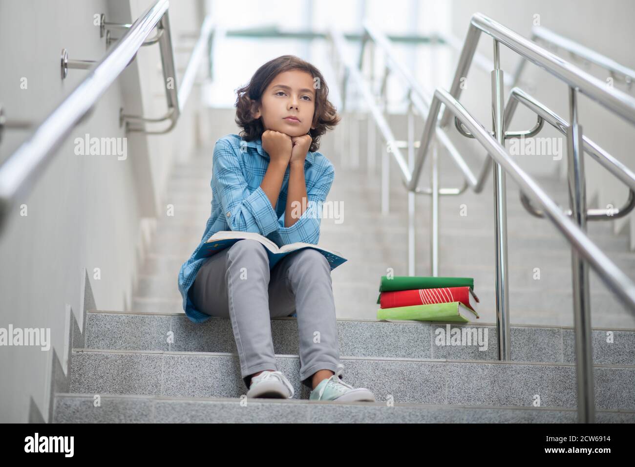Junge mit traurigem Gesicht sitzt auf Treppen Stockfoto