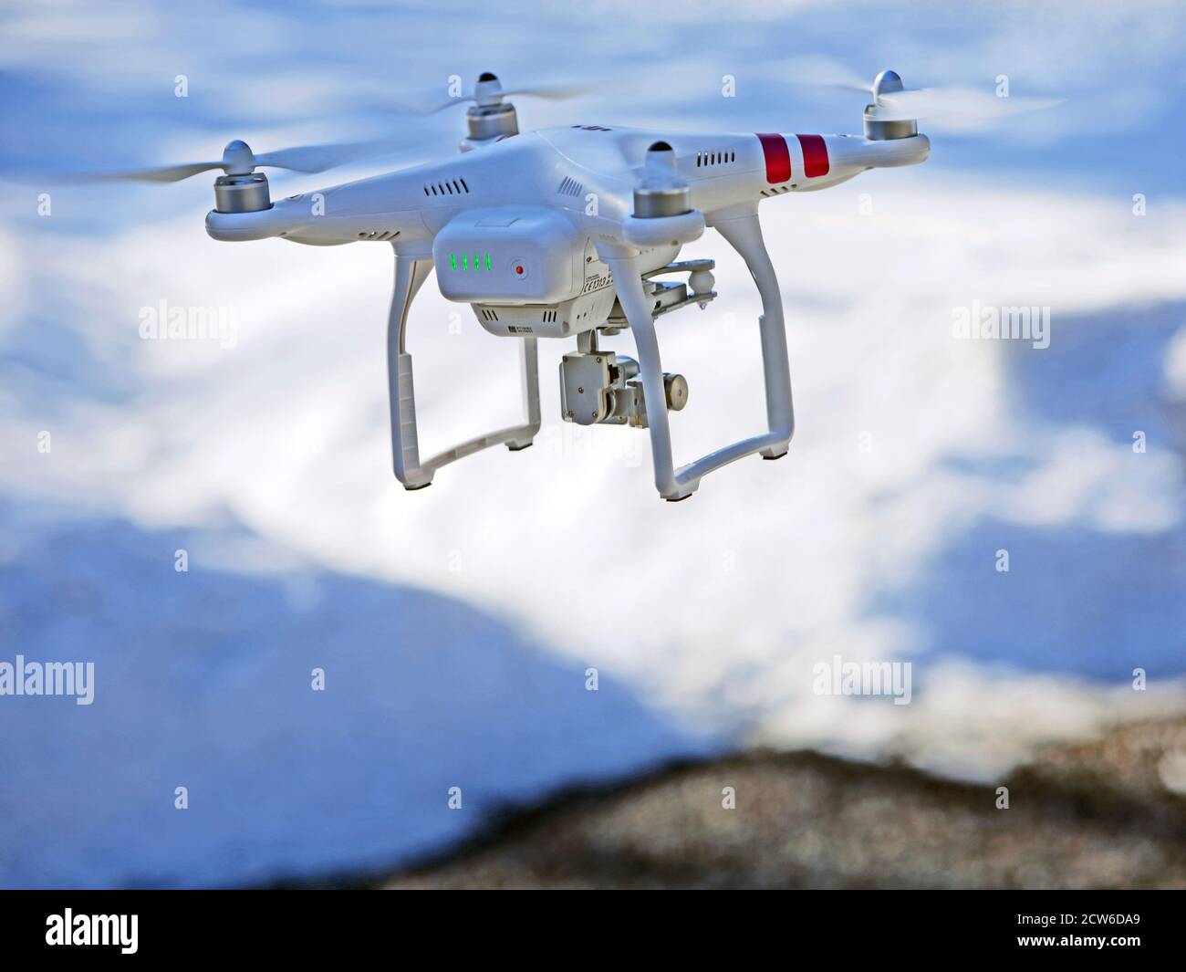 Quad-copter Drohne mit Videokamera auf Such-und Rettungsmission befestigt, fliegen tief über verschneiten Boden. Stockfoto