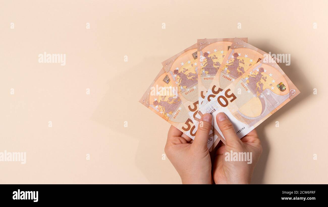 Ein Mann hält viele 50-Euro-Banknoten in den Händen. Ein Banner mit einem Platz für Text. Stockfoto