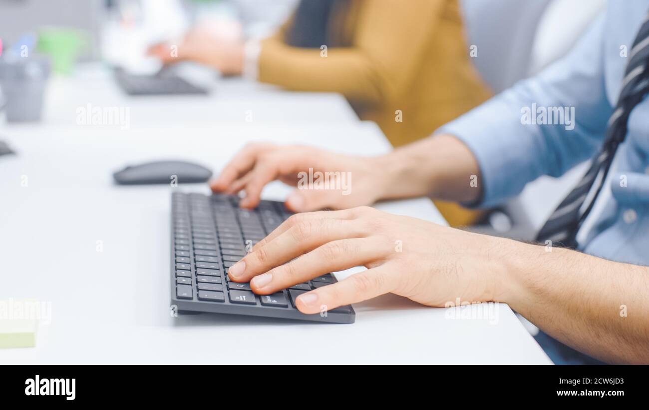Nahaufnahme des Mannes, der mit der Maus auf einer Tastatur tippt. Geschäftsmann Büroangestellter arbeitet am Desktop-Computer in Bright Office Stockfoto
