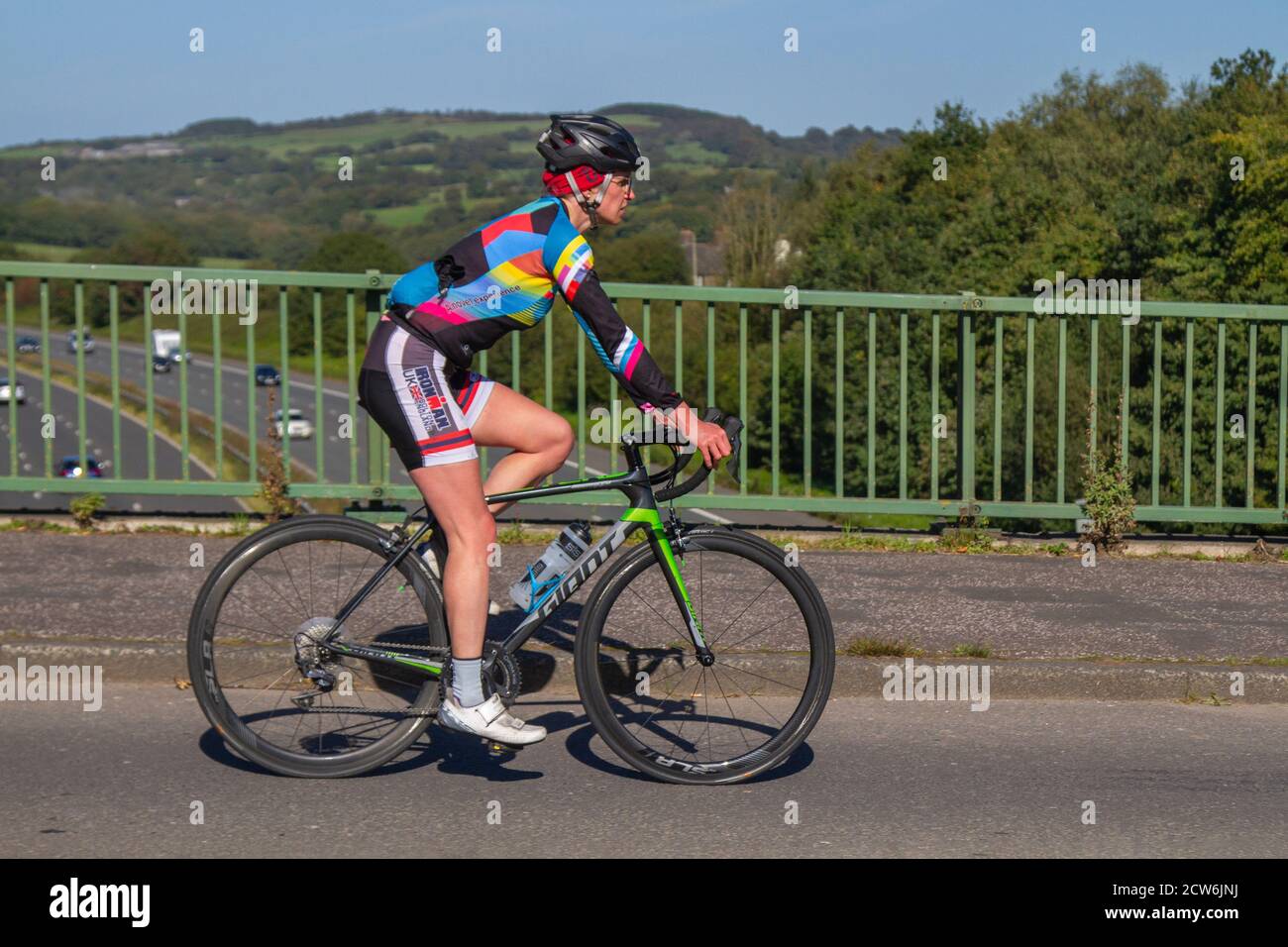 Männlicher Radfahrer Reiten Sport Rennrad auf dem Land Route über Autobahnbrücke in ländlichen Lancashire, Großbritannien Stockfoto