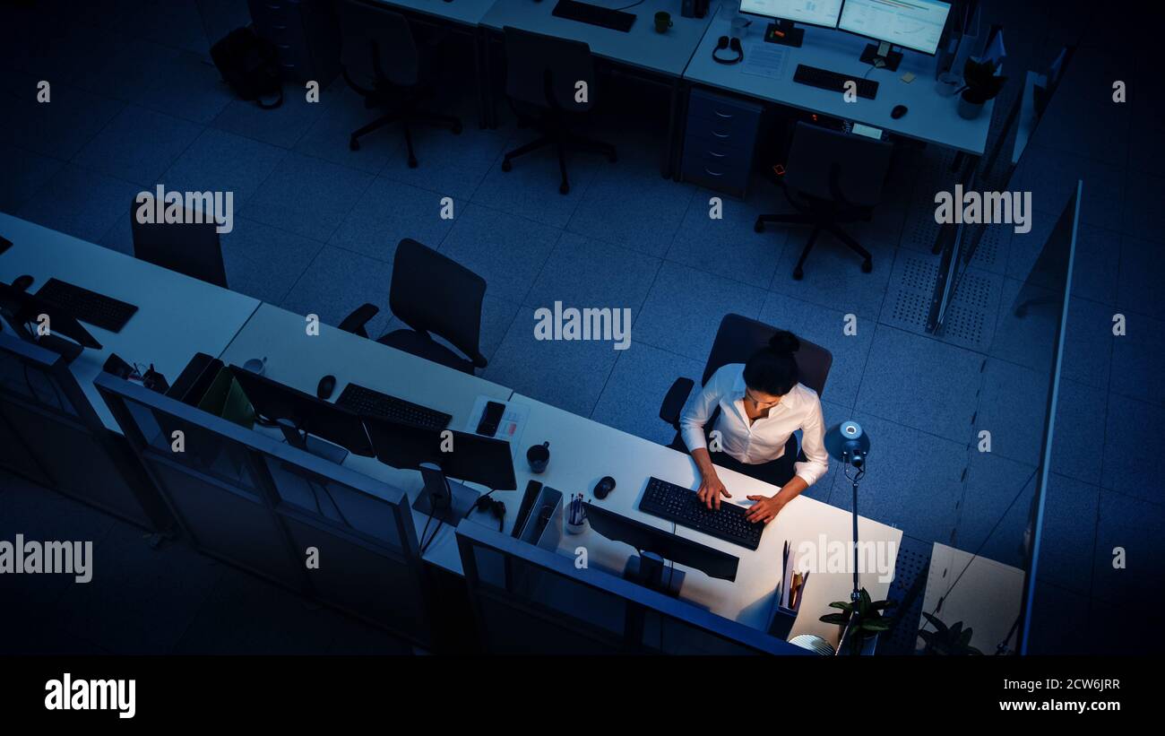 Allein spät in der Nacht im Büro arbeiten: Geschäftsfrau mit Desktop-Computer, analysieren, Dokumente verwenden, Probleme lösen, Projekt abschließen. Hoch Stockfoto