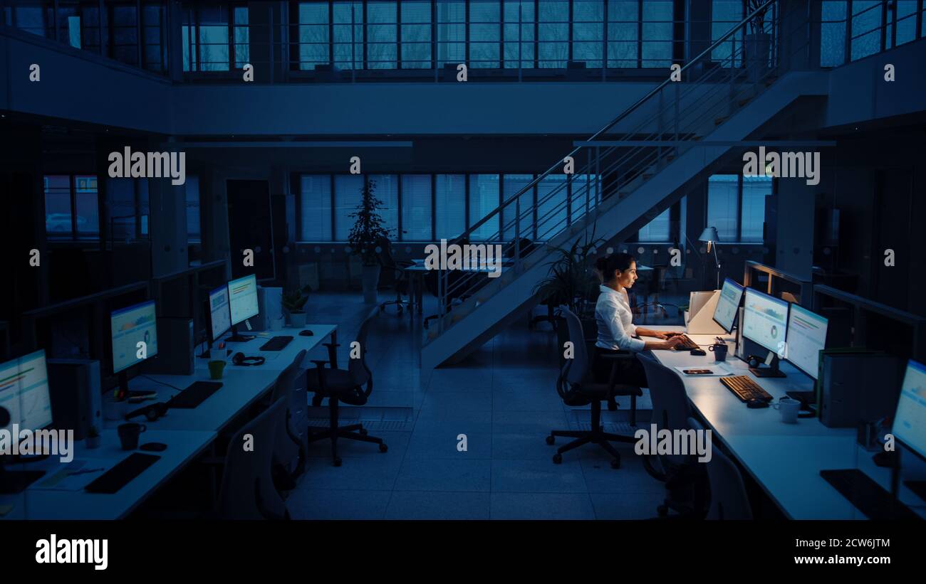 Allein spät in der Nacht im Büro arbeiten: Geschäftsfrau mit Desktop-Computer, analysieren, Dokumente verwenden, Probleme lösen, Projekt abschließen Stockfoto
