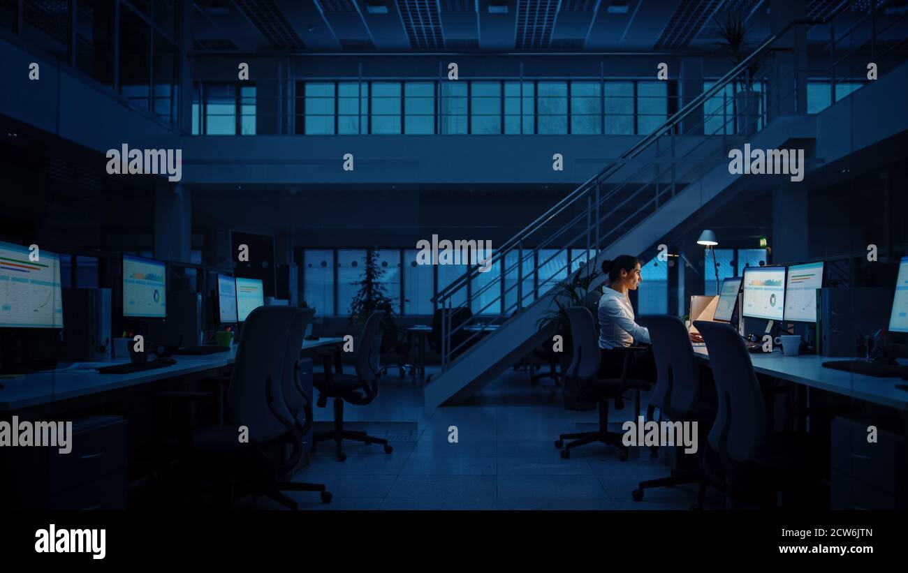 Allein spät in der Nacht im Büro arbeiten: Geschäftsfrau mit Desktop-Computer, analysieren, Dokumente verwenden, Probleme lösen, Projekt abschließen Stockfoto