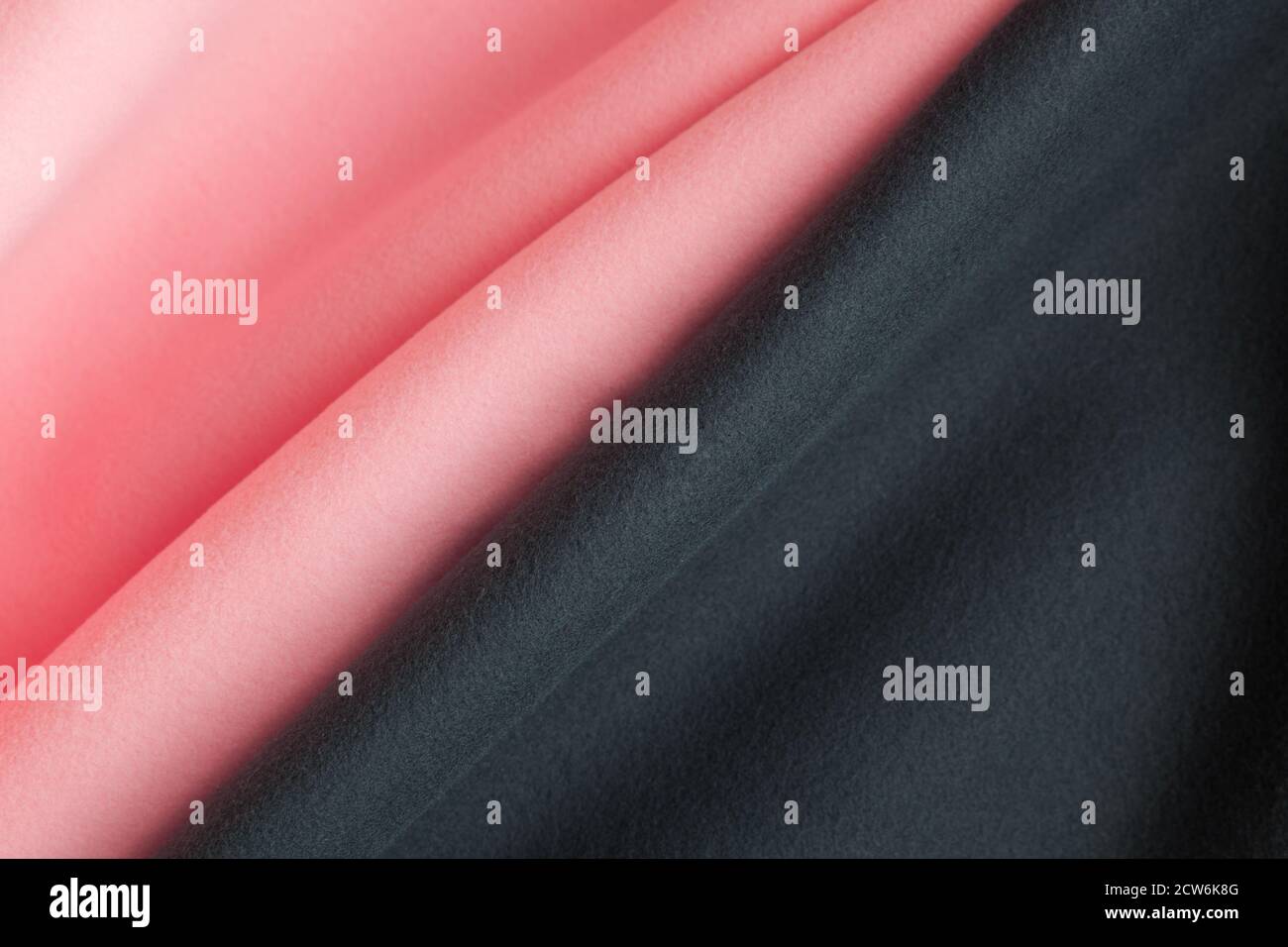 Hintergrundtextur aus rosa und schwarzem Fleece, weich aufgerautes Isoliergewebe aus Polyester Stockfoto
