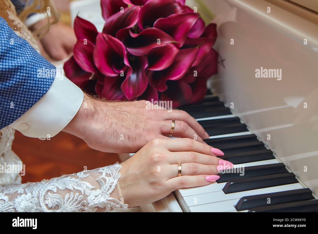 Hände eines Mannes und einer Frau mit Eheringen Auf den Klaviertasten Stockfoto