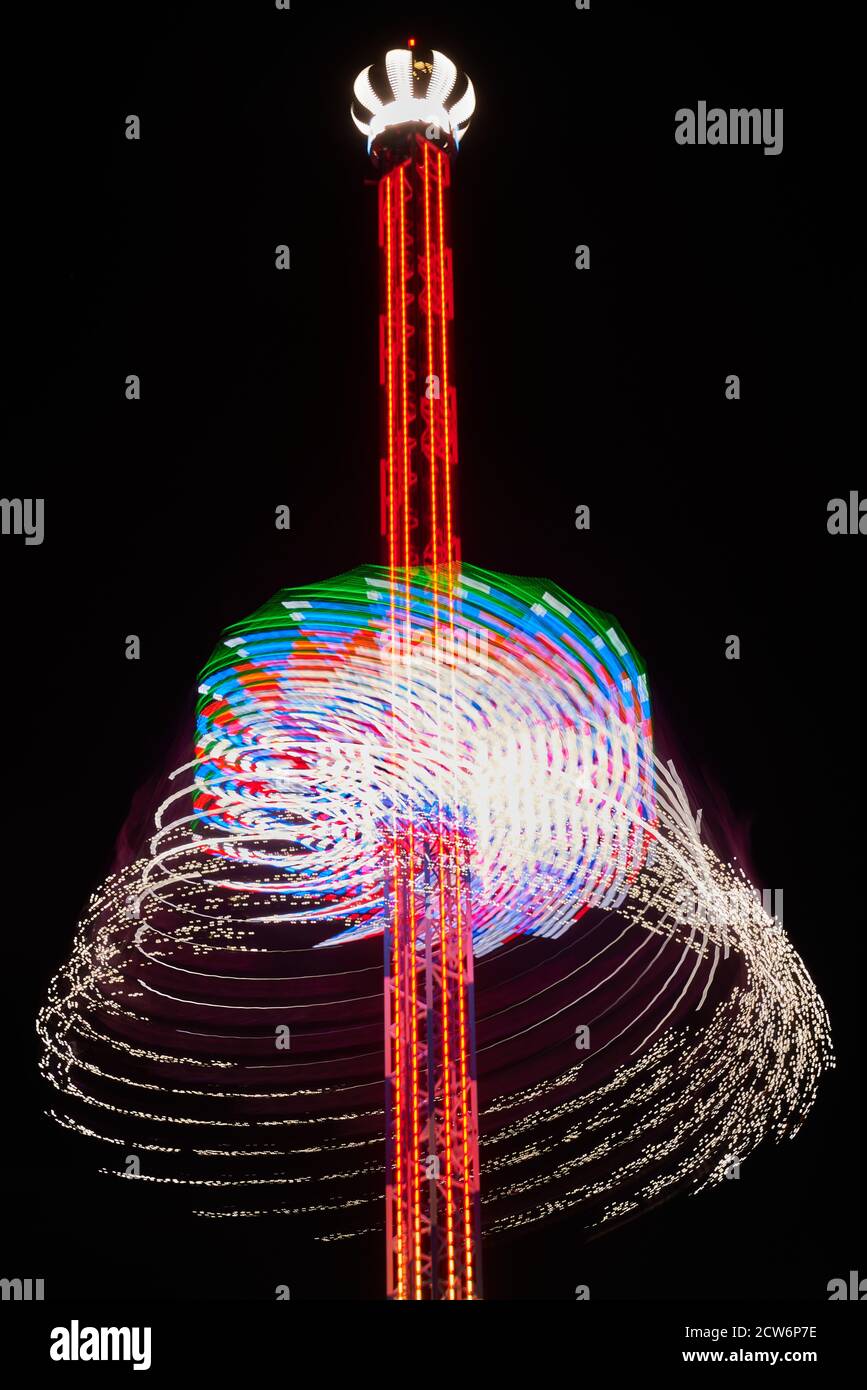Langzeitbelichtung eines Karussells in der Nacht. Langzeitbelichtung eines Riesenrads bei Nacht. Stockfoto