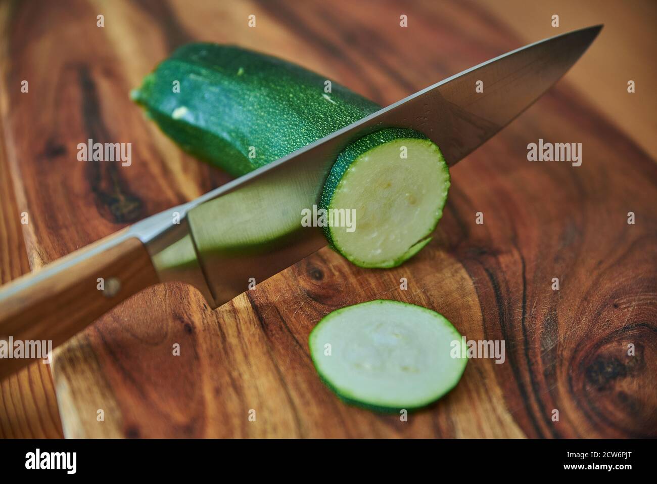 Holzschneidebrett mit frischem Gemüse und einem Kochmesser. Gemüse auf einem Holzschneidebrett hacken. Stockfoto