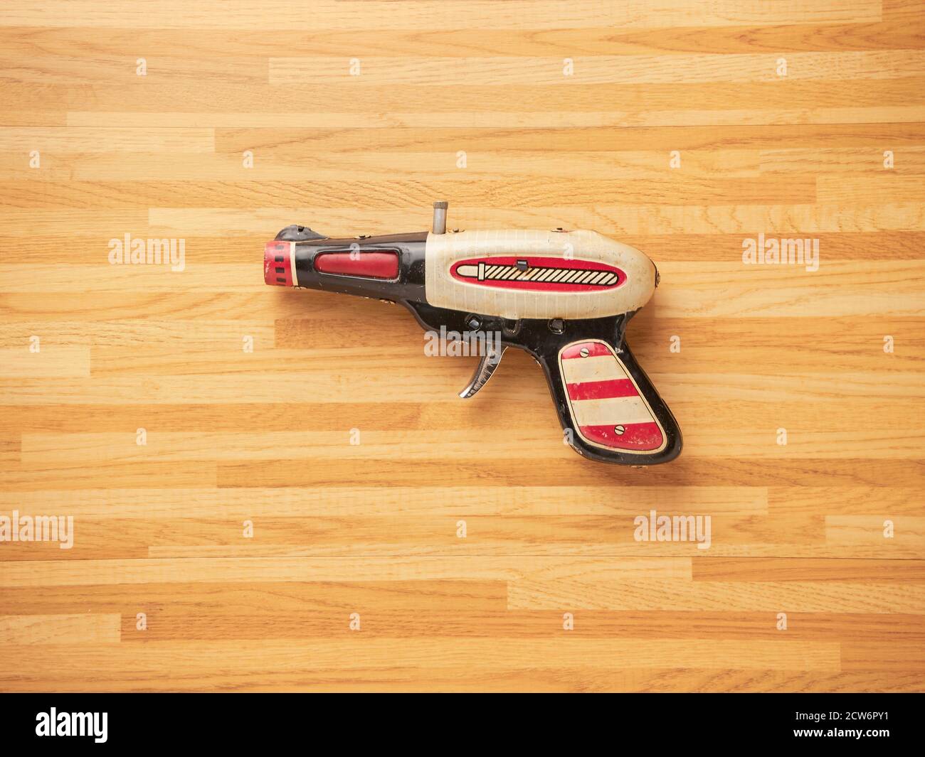 Zinn Spielzeugpistole mit einem Holztisch Hintergrund Stockfoto