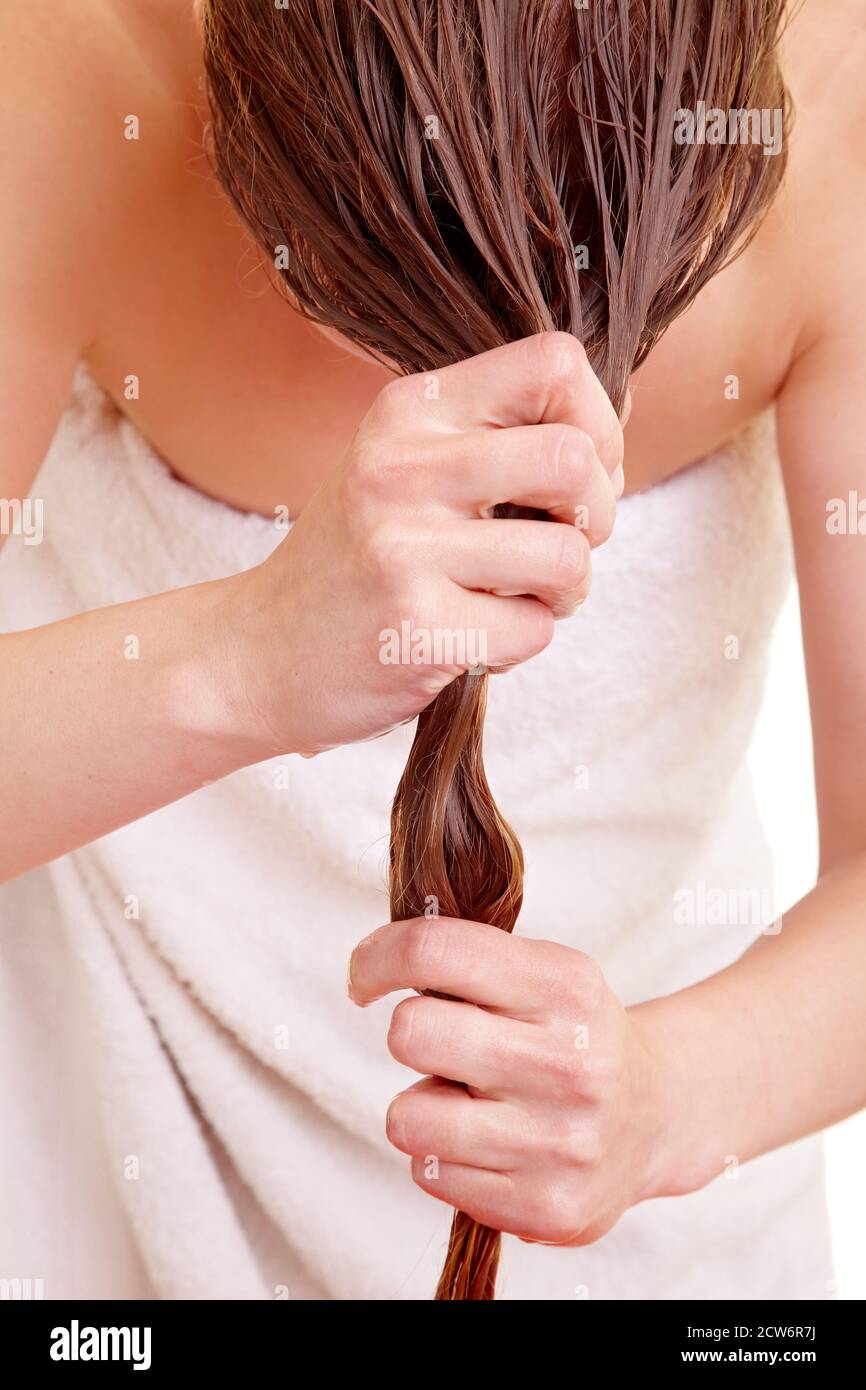 Blonde Frau trocknet ihre langen Haare Stockfoto