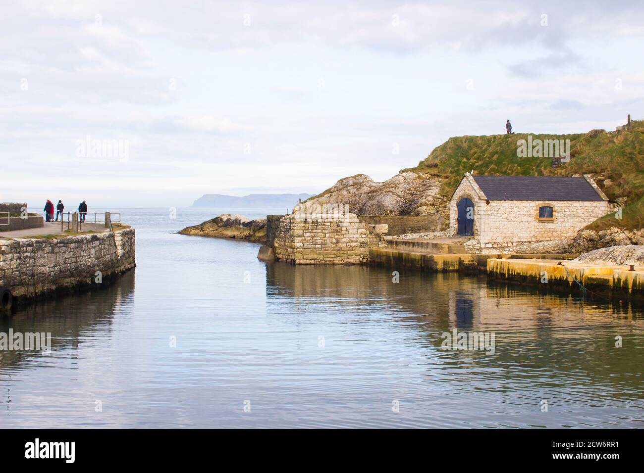Der kleine Hafen von ballintoy an der Nord Küste von Antrim, Nordirland mit seinen alten Stein Bootshaus an einem Tag im Frühling Stockfoto