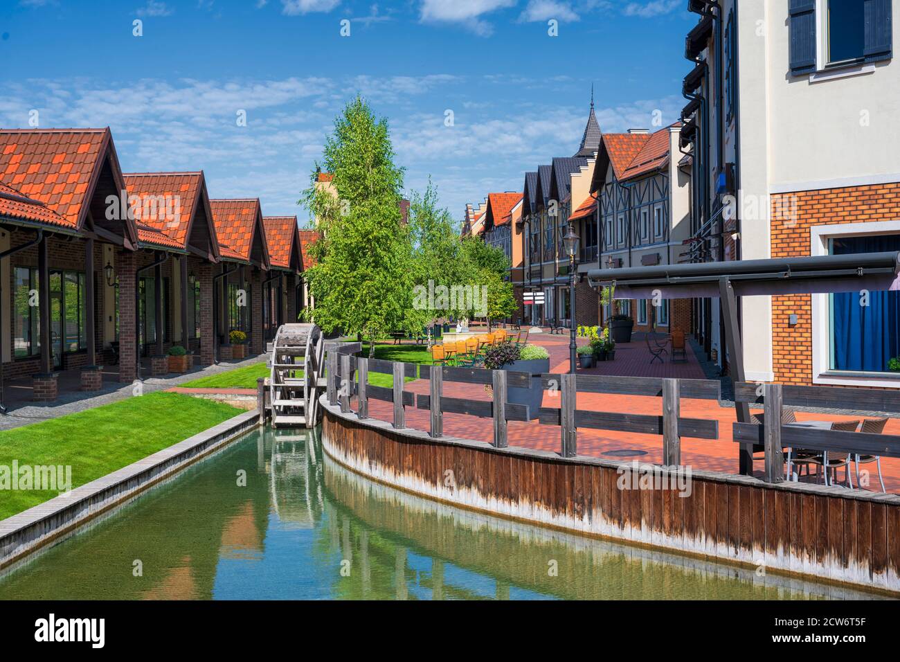 Bunte Altstadt in Europa mit Kanal und dekorativer Wassermühle. Postkarte aus Europa Stockfoto