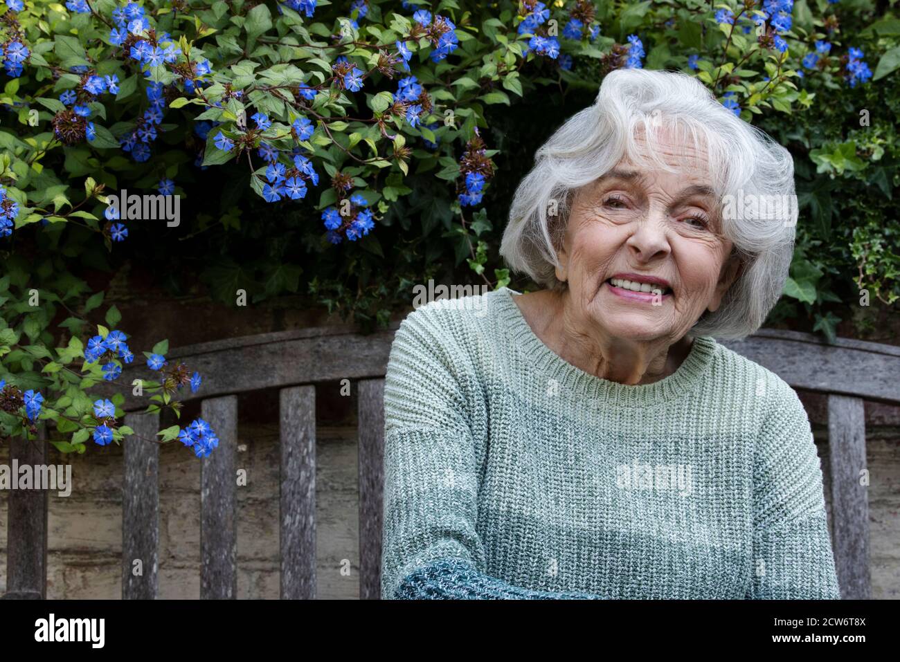 Porträt Einer Lächelnden Älteren Frau, Die Sich Im Garten Zu Hause Entspannt Stockfoto