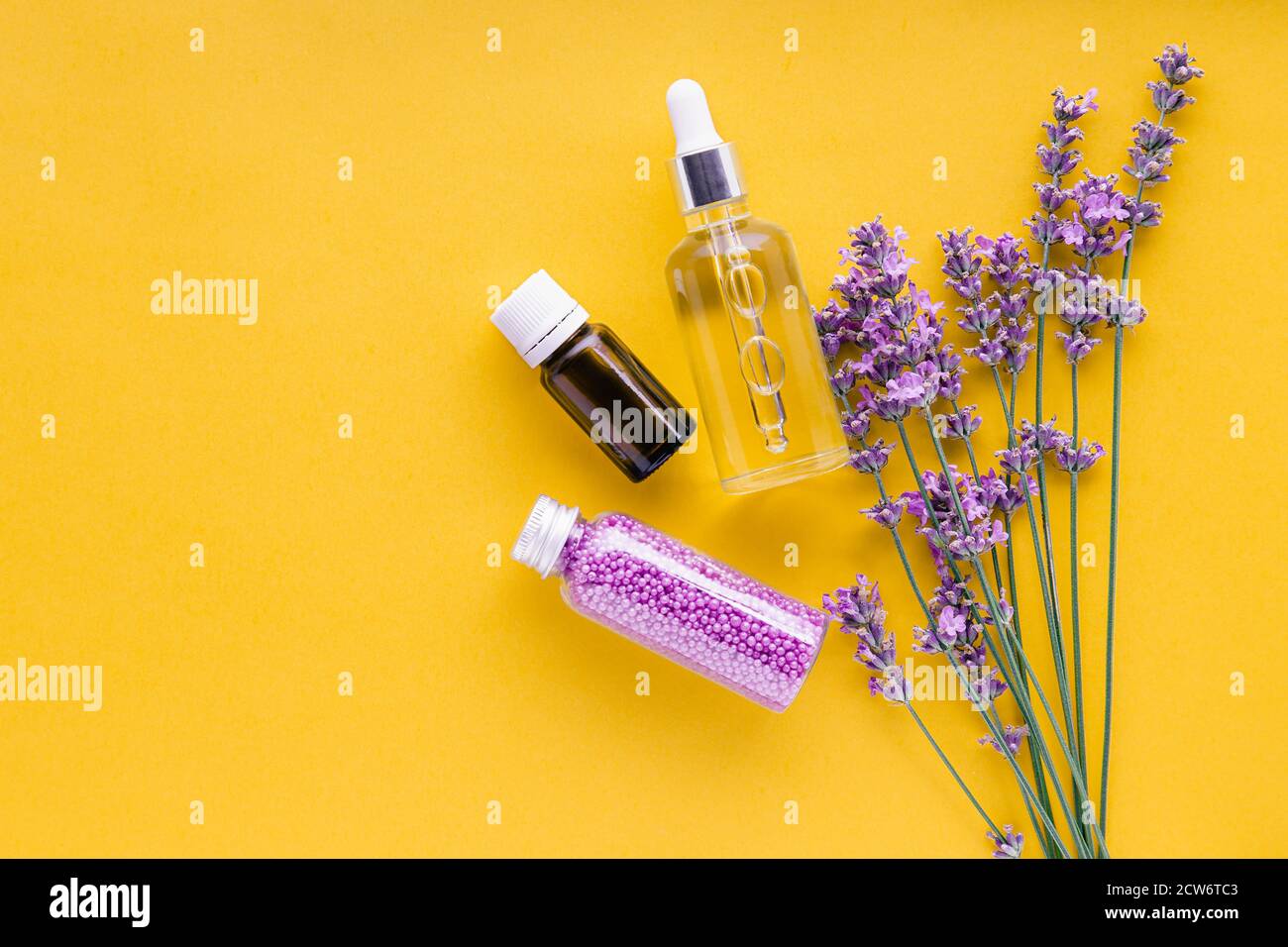 Bouquet von Lavendelblüten und Set Lavendel Hautpflegeprodukte. Natürliche Spa Beauty-Produkte frische Lavendelblüten Kräuter auf gelbem Hintergrund Stockfoto
