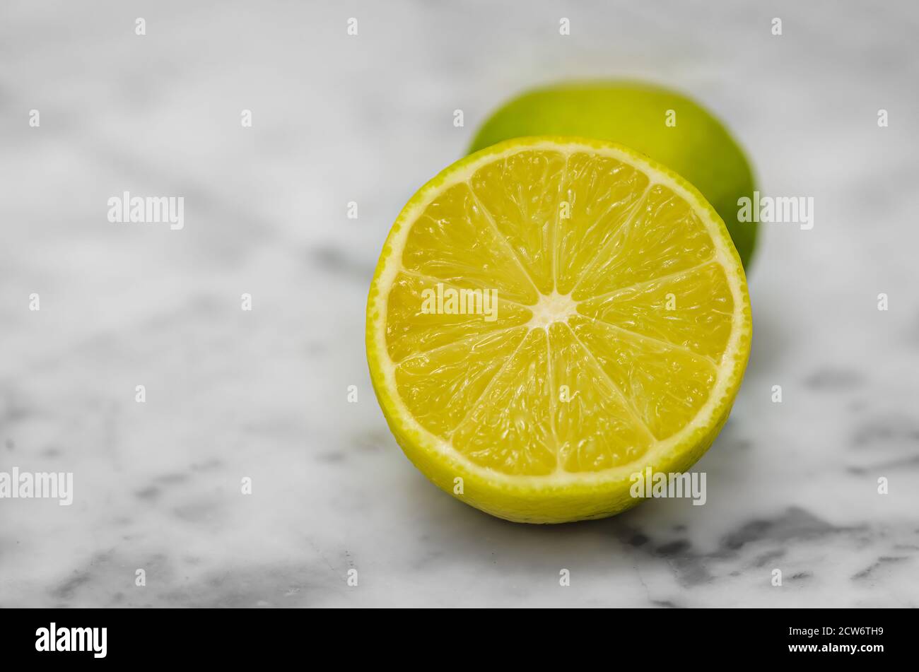 Nahaufnahme einer geschnittenen Zitrone auf dem weißen Marmortisch. Makroaufnahme. Stockfoto