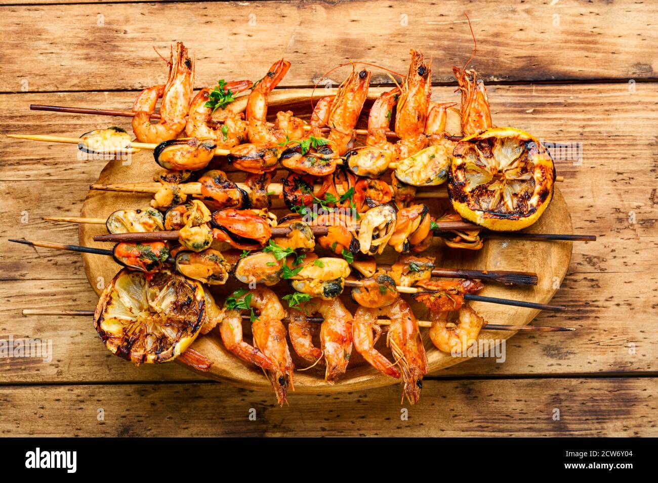 Gegrillte Garnelen und Muscheln auf Holzstäbchen Stockfoto