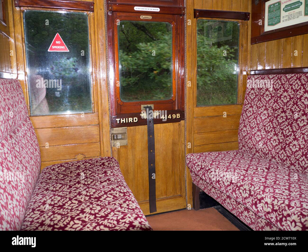Historische Eisenbahnwaggon Interieur mit polierter Holzvertäfelung und Drop-down-Fenster zum Öffnen .das Fenster wurde angehoben und gesenkt mit einem Lederband. Stockfoto