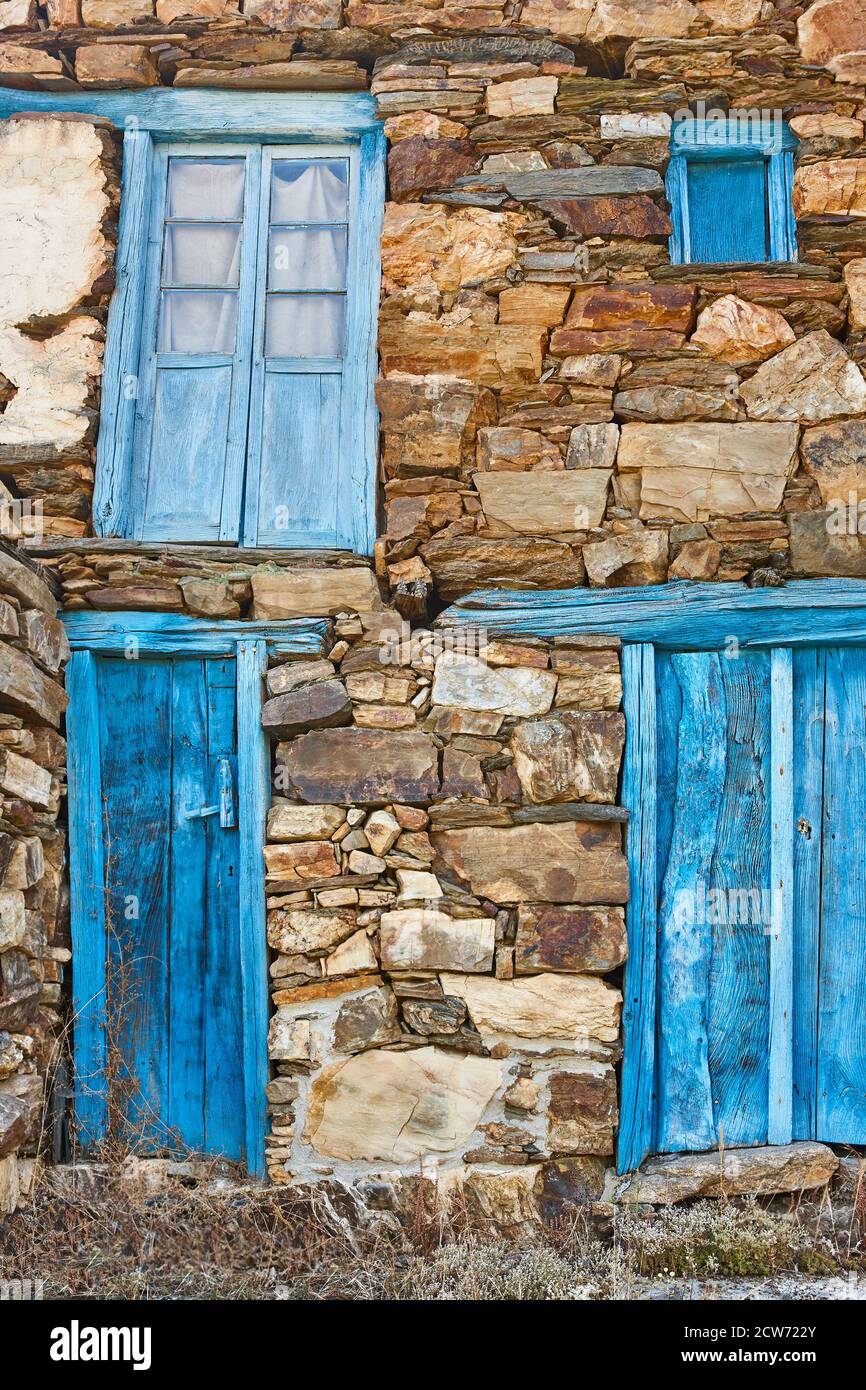 Malerisch blaue Grunge Türen und Fenster auf rustikalen Steinmauer Stockfoto