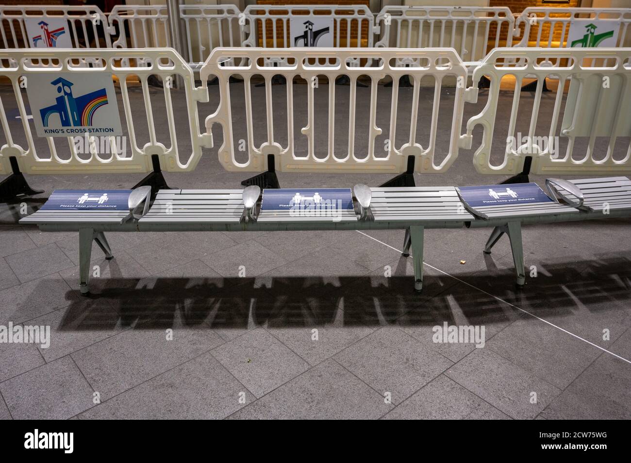 LONDON - 14. SEPTEMBER 2020: Eine Reihe A Sitze mit Social Distancing Zeichen und Menschenmengen-Kontrolle Barrieren im Hintergrund bei King's Cross Bahnhof d Stockfoto