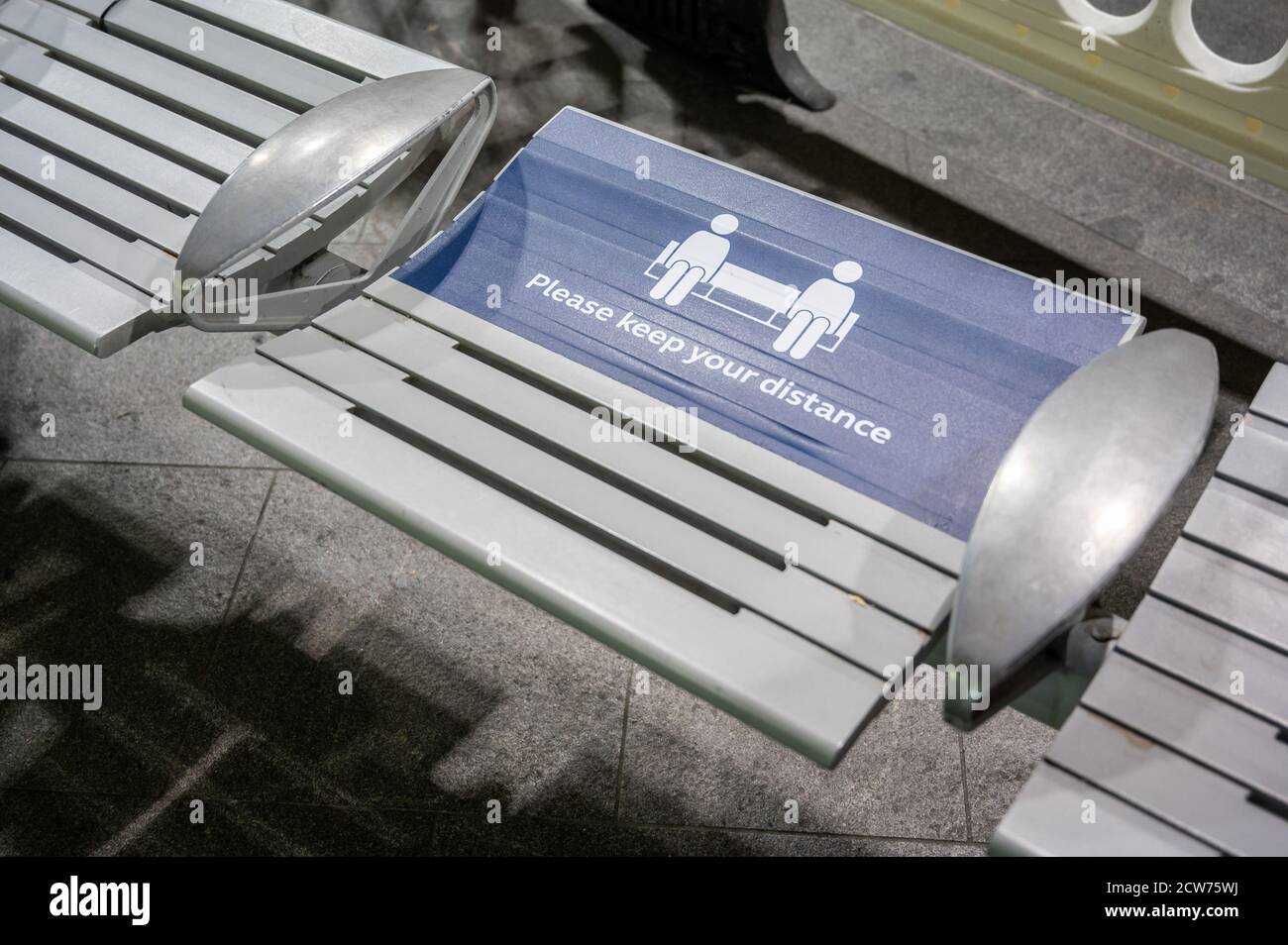 LONDON - 14. SEPTEMBER 2020: Warnschild zur sozialen Distanzierung auf einem Sitz am Bahnhof King's Cross während der Pandemie von Covid 19 Stockfoto