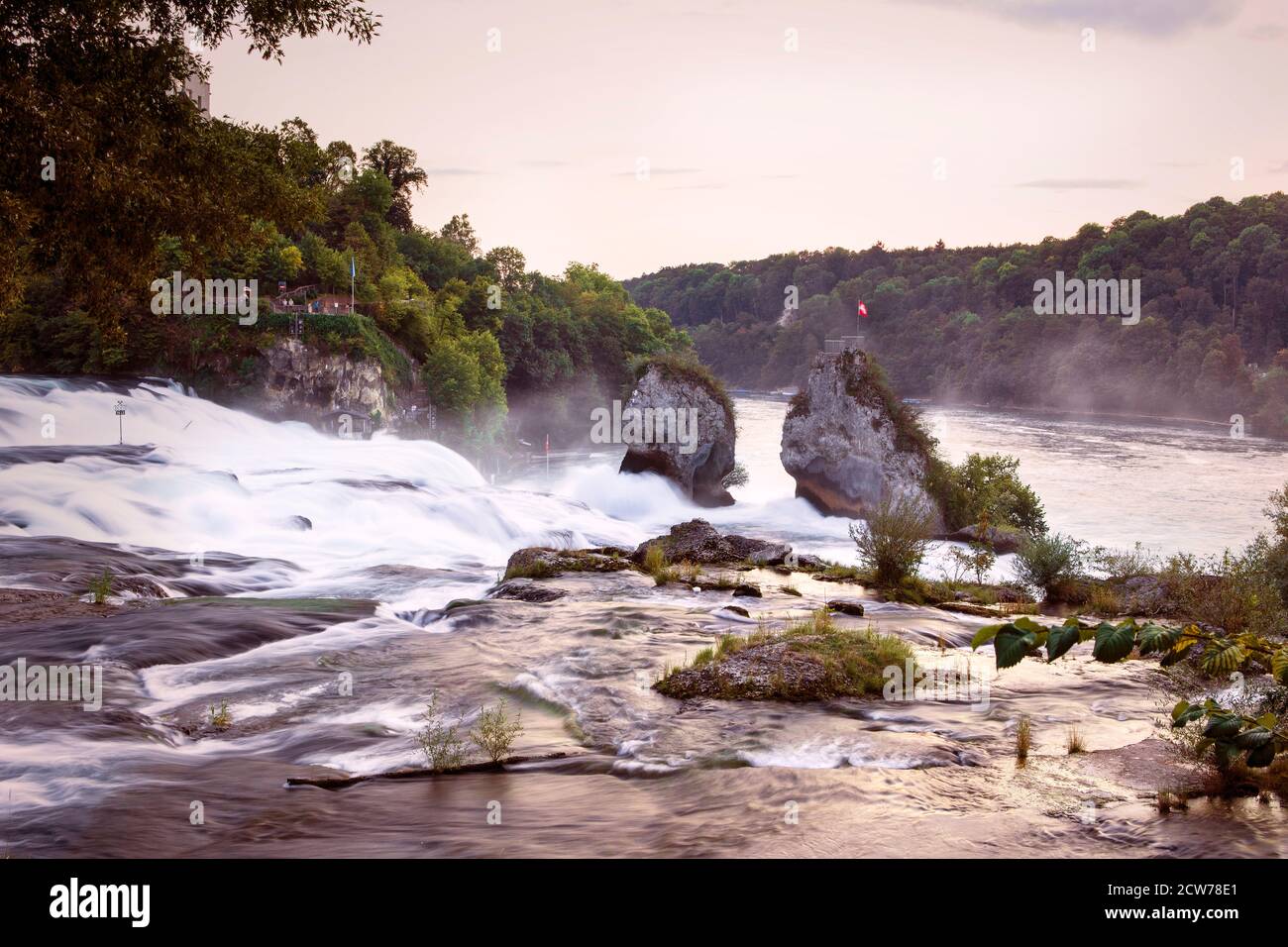 Größter Wasserfall in Europa bei Sonnenuntergang Licht. Rheinfall. Felsen über dem Fluss mit einem wunderschönen Wasserfall am Rhein. Neuhausen bei Schaffhausen Stockfoto
