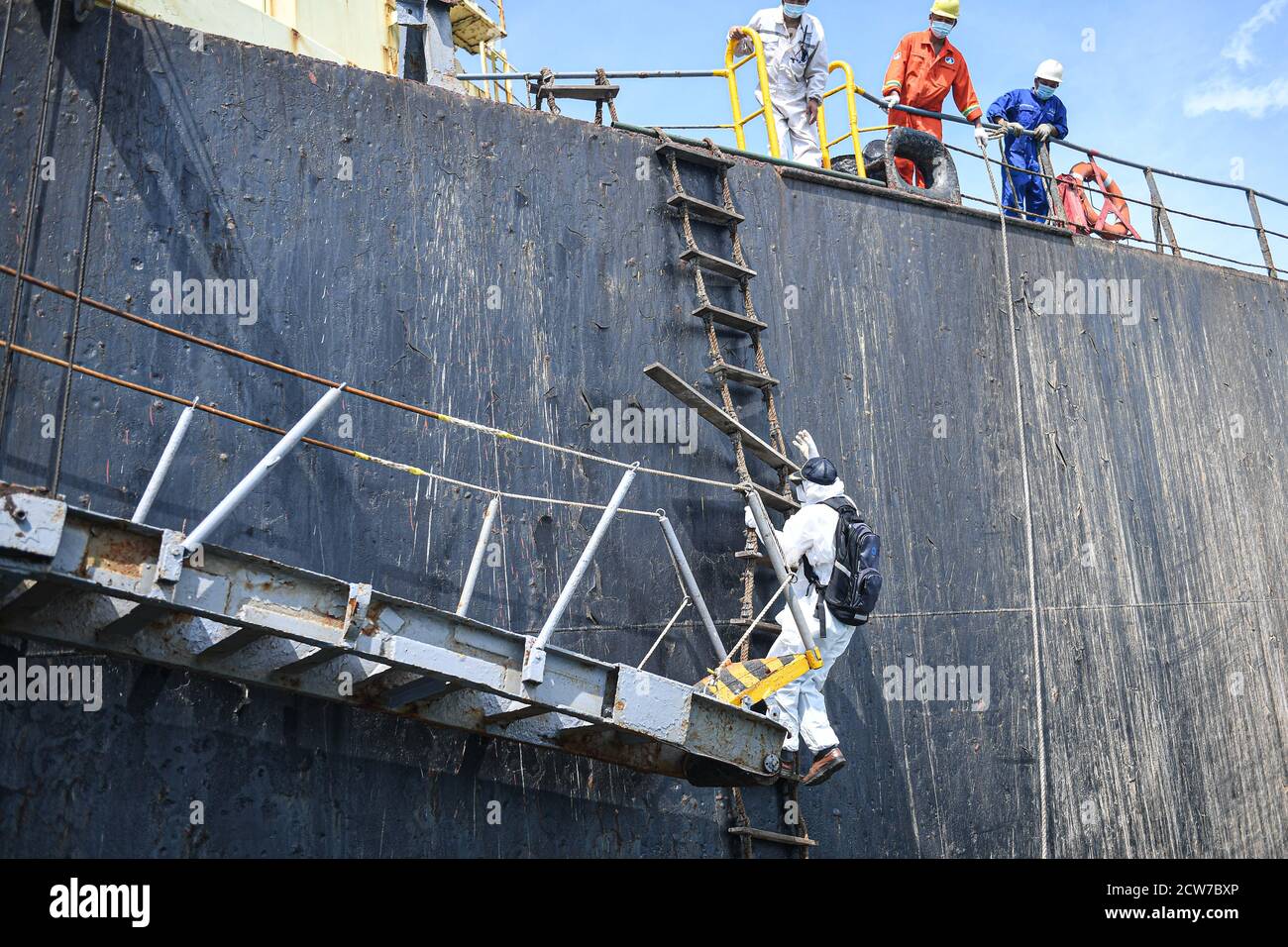 (200928) -- YANGPU, 28. September 2020 (Xinhua) -- Navigator Lin Daomin mit Schutzausrüstung steigt die Leiter eines Schiffes aus dem Ausland in Yangpu, südchinesische Provinz Hainan, 26. September 2020. Ein qualifizierter Hafennavigator muss mit der lokalen hydrologischen Umgebung vertraut sein und Schiffe navigieren, um reibungslos anzudocken. Derzeit arbeiten insgesamt 22 Seefahrer an fünf verschiedenen Docks in Hainan. Trotz unsicherer Arbeitszeiten und verschiedener Wetterbedingungen bewältigt sie die Belastung sowohl körperlich als auch geistig. In den letzten Monaten im Jahr 2020 haben Seefahrer Schiffe für über 4,200 mal t geführt Stockfoto