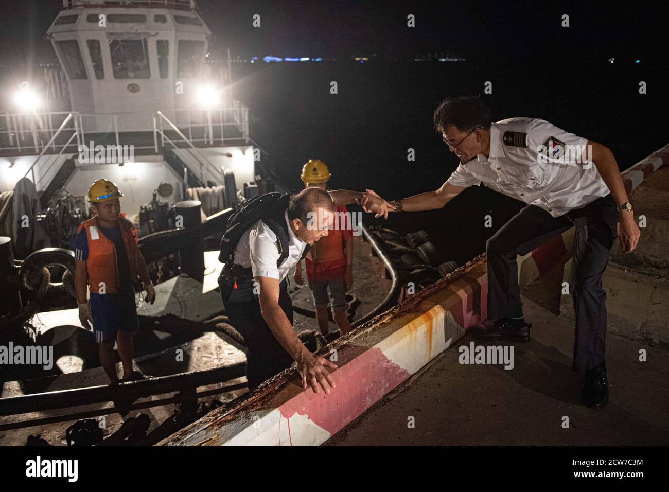 (200928) -- YANGPU, 28. September 2020 (Xinhua) -- Navigator Chen Yinghua (1. R) hilft seinem Mitarbeiter Lin Daomin (2. L), ebenfalls ein Navigator, am 23. September 2020 in Yangpu, der südchinesischen Provinz Hainan, an Land zu gehen. Ein qualifizierter Hafennavigator muss mit der lokalen hydrologischen Umgebung vertraut sein und Schiffe navigieren, um reibungslos anzudocken. Derzeit arbeiten insgesamt 22 Seefahrer an fünf verschiedenen Docks in Hainan. Trotz unsicherer Arbeitszeiten und verschiedener Wetterbedingungen bewältigt sie die Belastung sowohl körperlich als auch geistig. In den letzten Monaten im Jahr 2020 haben Seefahrer Schiffe für über 4 geführt Stockfoto