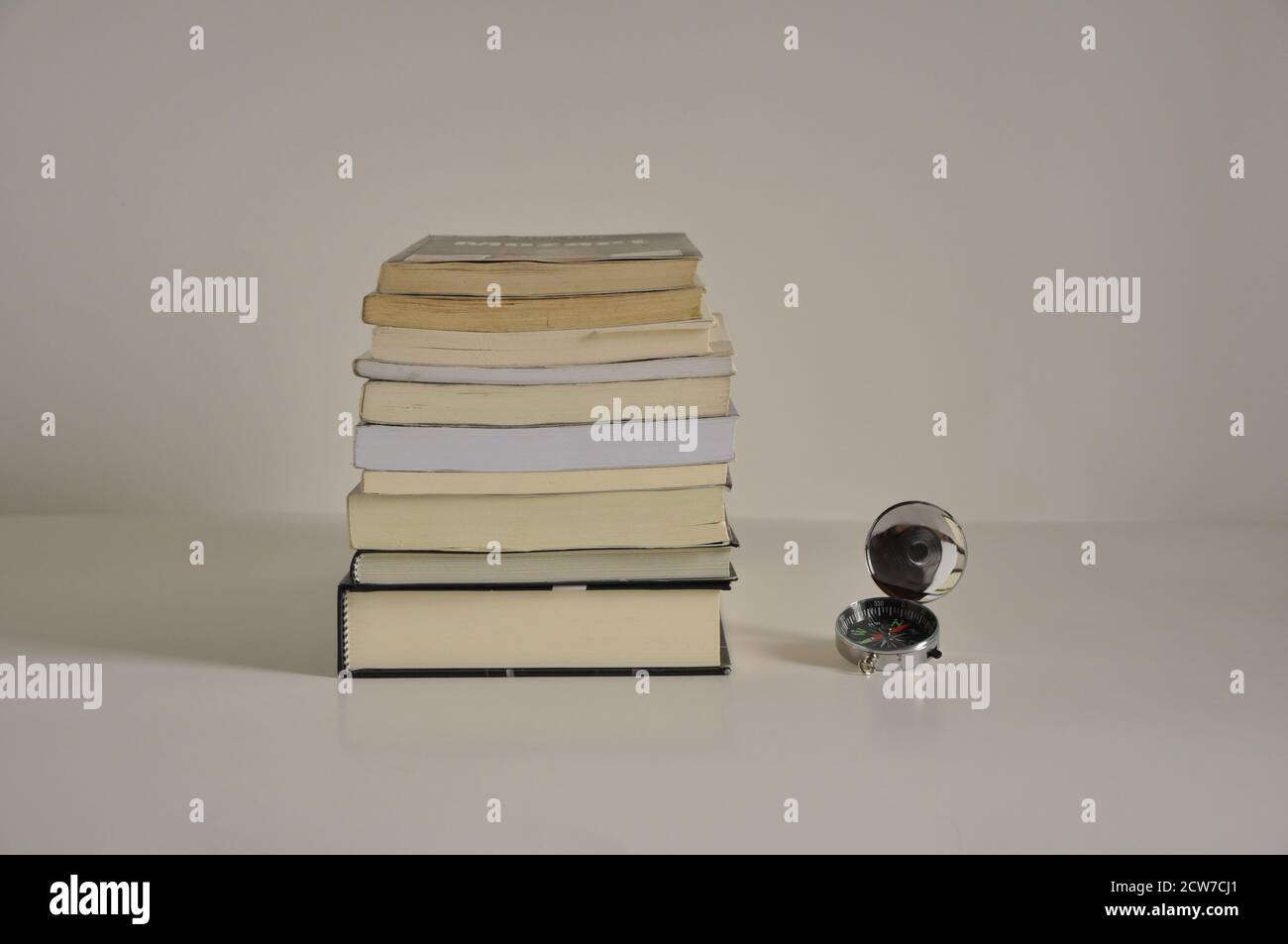 Bücherstapel, Bücher zu verschiedenen Themen, Konzeptfoto, mit Kompass an der Seite, Seitenansicht, weißer Hintergrund, Brasilien, Südamerika, Speicherplatz kopieren Stockfoto