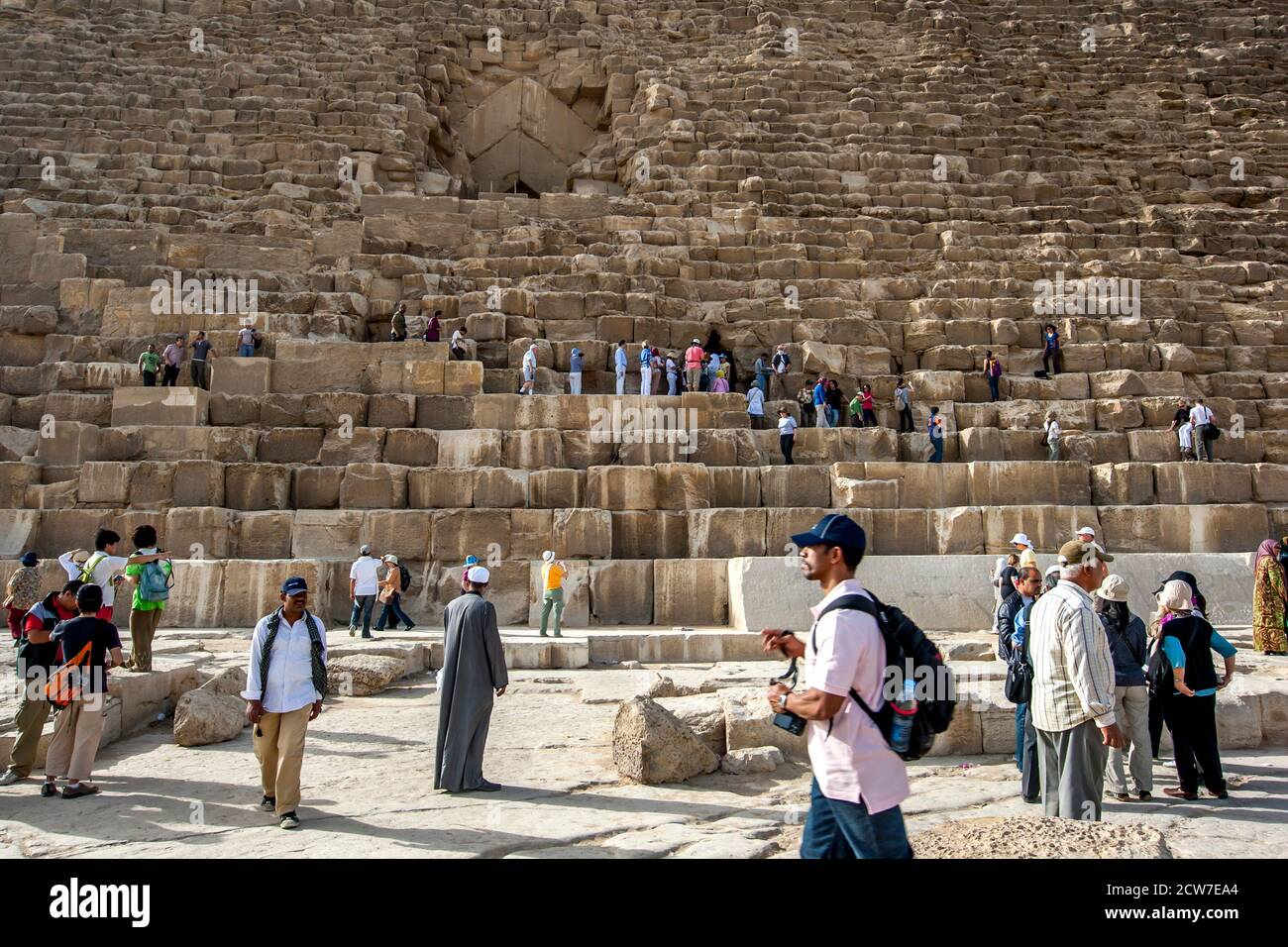 Besucher des Gizeh-Plateaus in Kairo in Ägypten klettern über die riesigen Steinblöcke der Pyramide von Khufu. Stockfoto