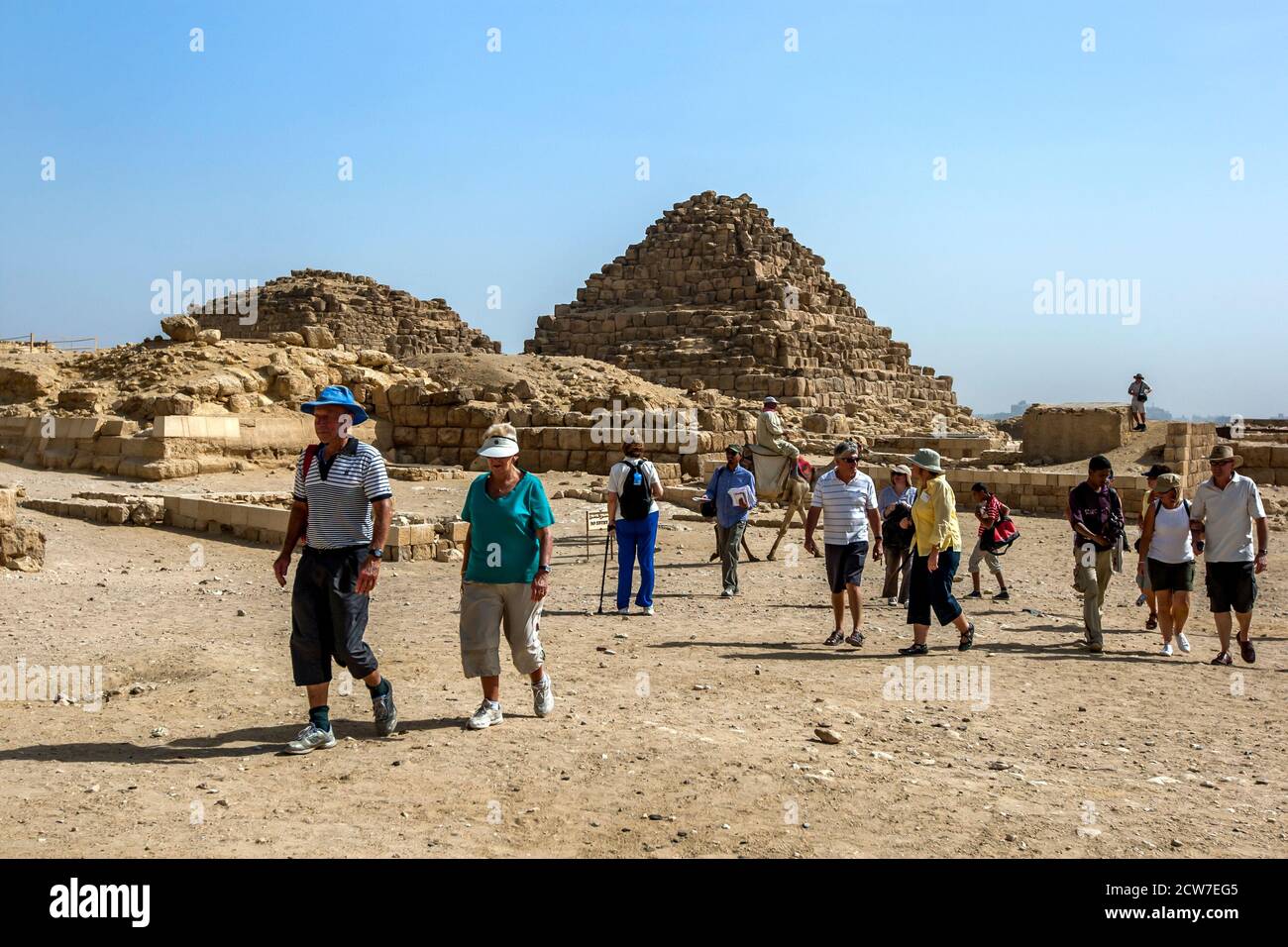 Besucher des Gizeh-Plateaus in Kairo in Ägypten wandern an den Pyramiden der Königinnen vorbei, die an die Pyramide von Khufu anschliessen. Stockfoto