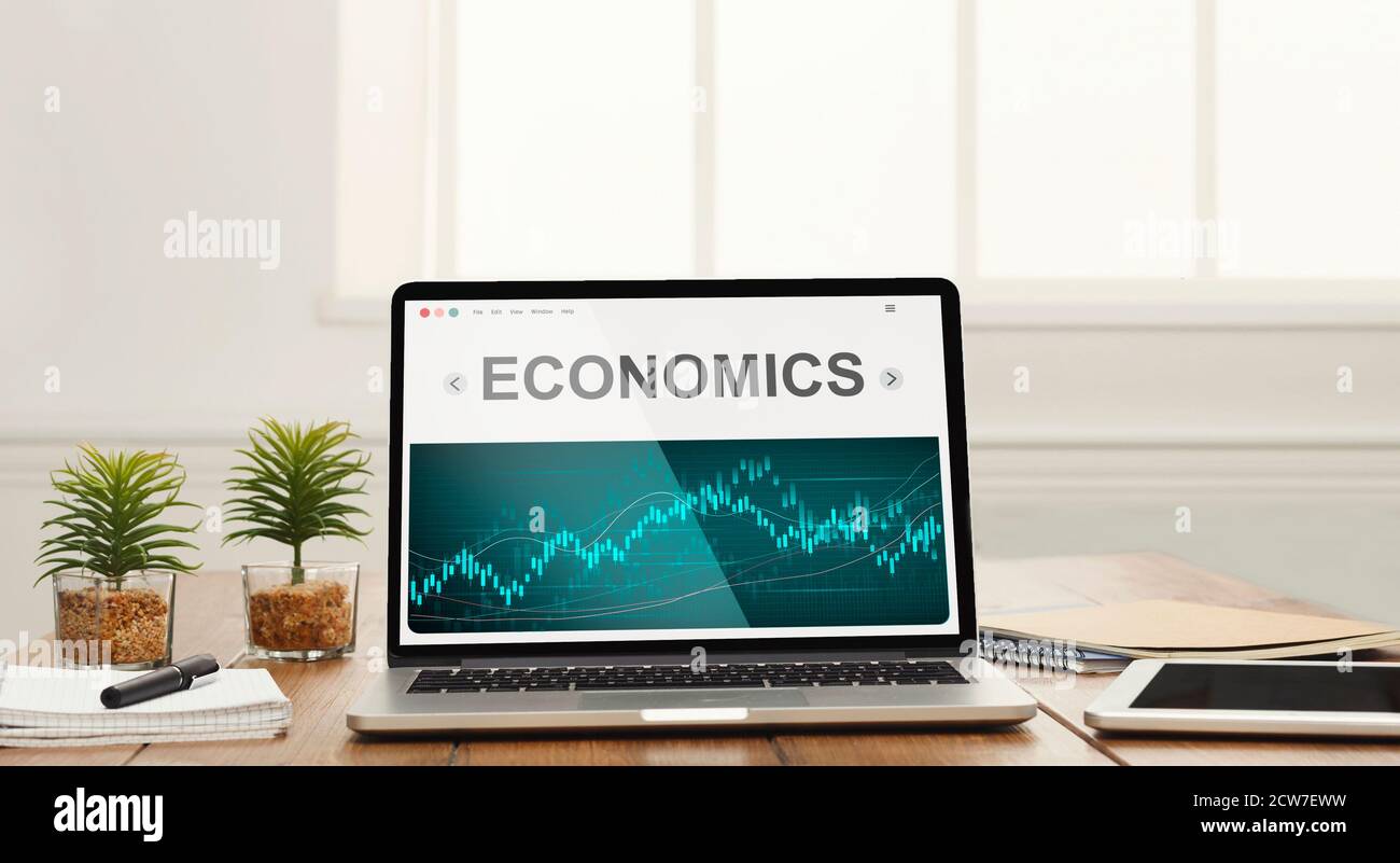 Laptop Mit Word Economics Auf Dem Bildschirm, Der Auf Dem Schreibtisch Steht Stockfoto