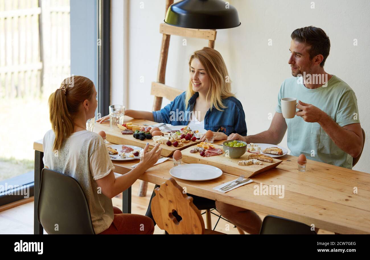 Freunde haben gute Zeit am Esstisch Stockfoto
