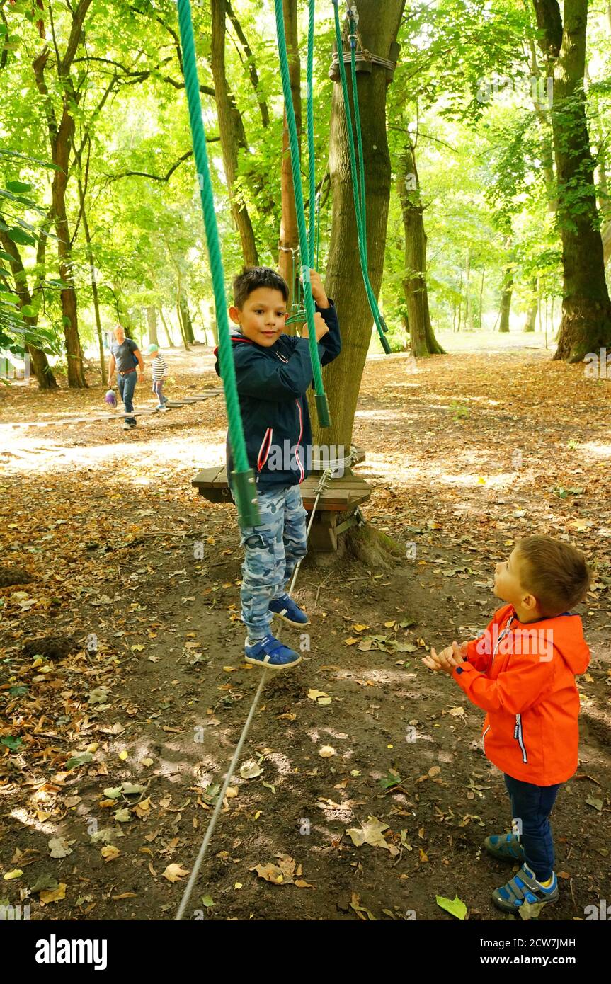 JANKOWICE, POLEN - 06. Sep 2020: Kind steht auf einem Seil einer Hindernisstrecke in einem Park. Stockfoto