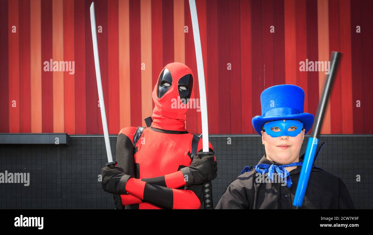 Eine Figur Cosplayer posiert als Deadpool (l) und Begleiter bei MCM comicon London, UK Stockfoto