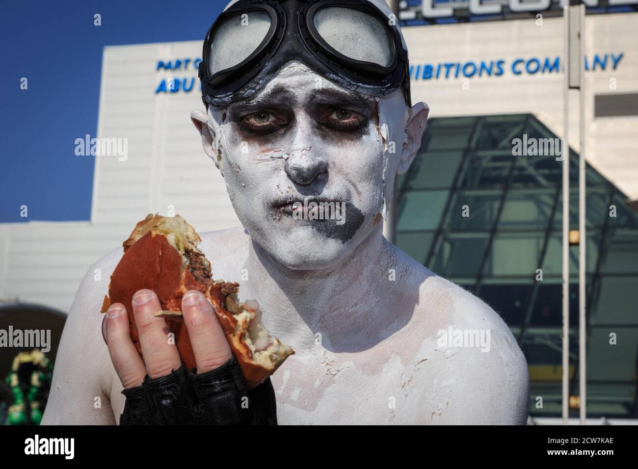 Ein Cosplayer munches auf seinem Burger in Ganzkörperfarbe bei MCM comicon London, Großbritannien Stockfoto