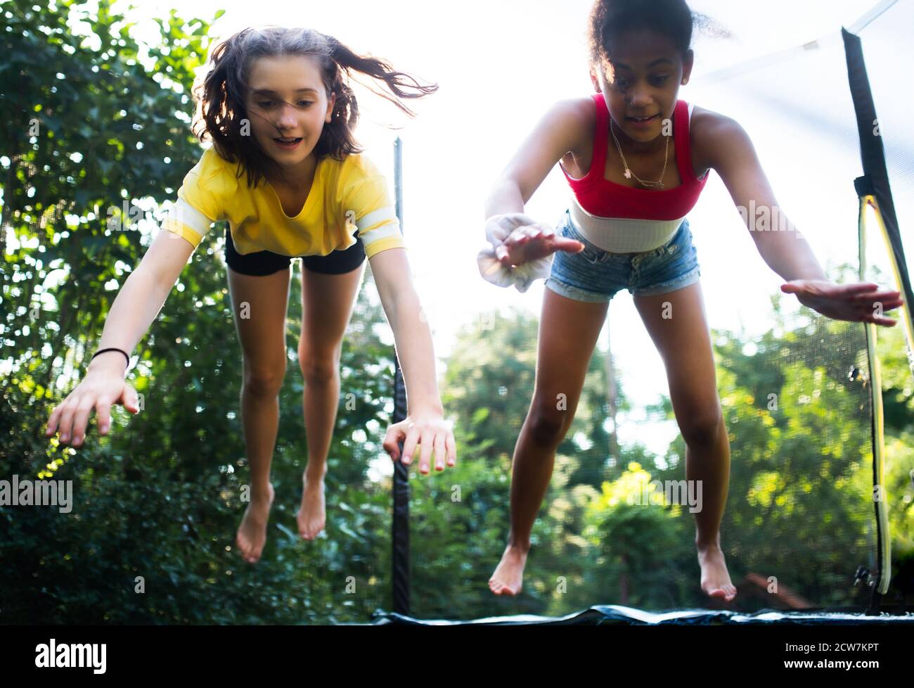 Frontansicht der jungen Teenager Mädchen Freunde im Freien im Garten, springen auf Trampolin. Stockfoto