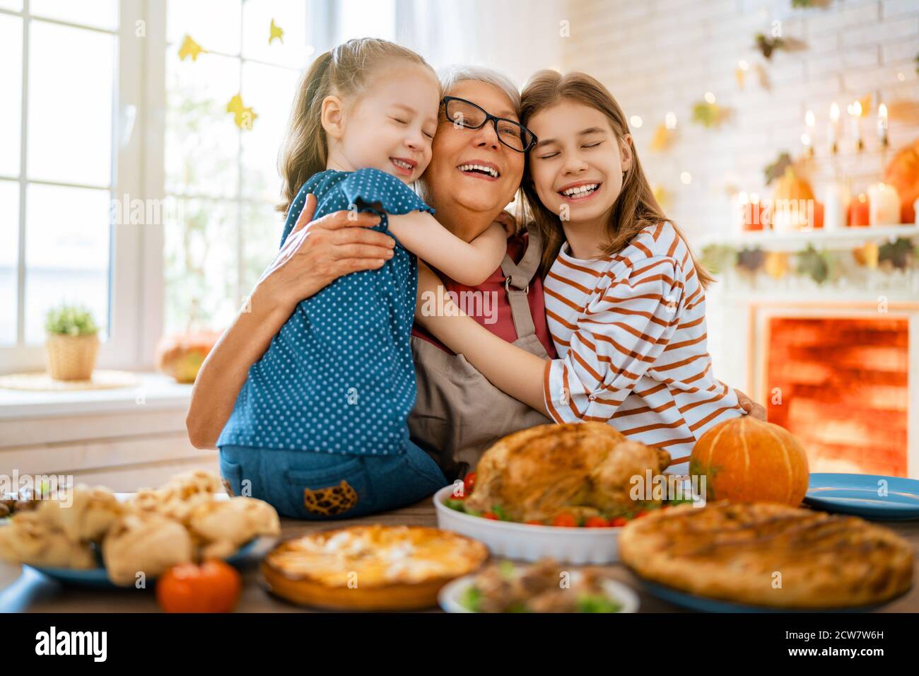 Alles Gute Zum Thanksgiving Herbstfest. Familie sitzt am Tisch und feiert Urlaub. Traditionelles Abendessen. Großmutter und Enkelinnen. Stockfoto