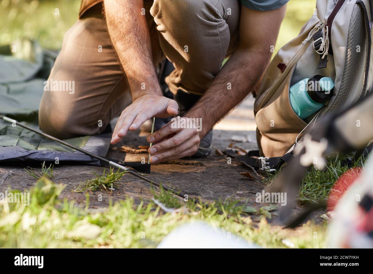 Nahaufnahme von unkenntlichen Mann setzen in Haken beim Einrichten Zelt für Camping in der Natur, kopieren Raum Stockfoto