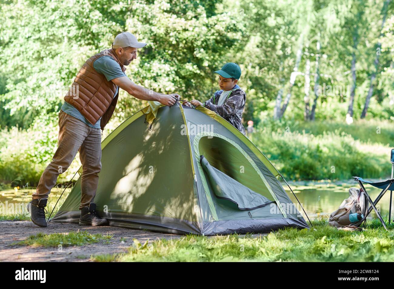 In voller Länge Porträt von Vater und Sohn zusammen Zelt beim Camping im Wald, Kopierer Raum Stockfoto