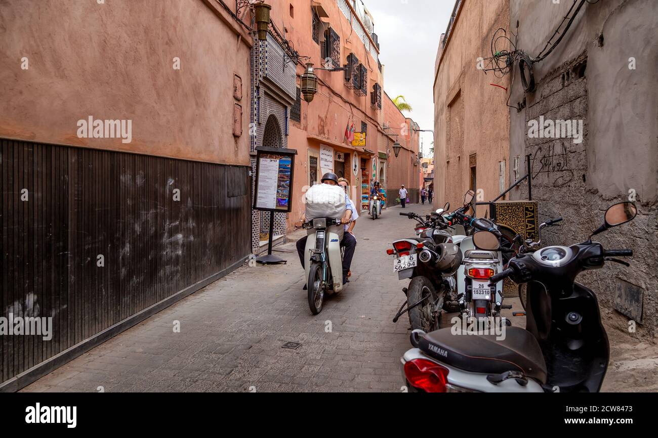 MARRAKESCH, MAROKKO-MAI 31 2019.: Motorradfahrer auf der Straße der Altstadt von Marrakesch. Roller sind die typischen Verkehrsmittel in der Medina von Marrake Stockfoto