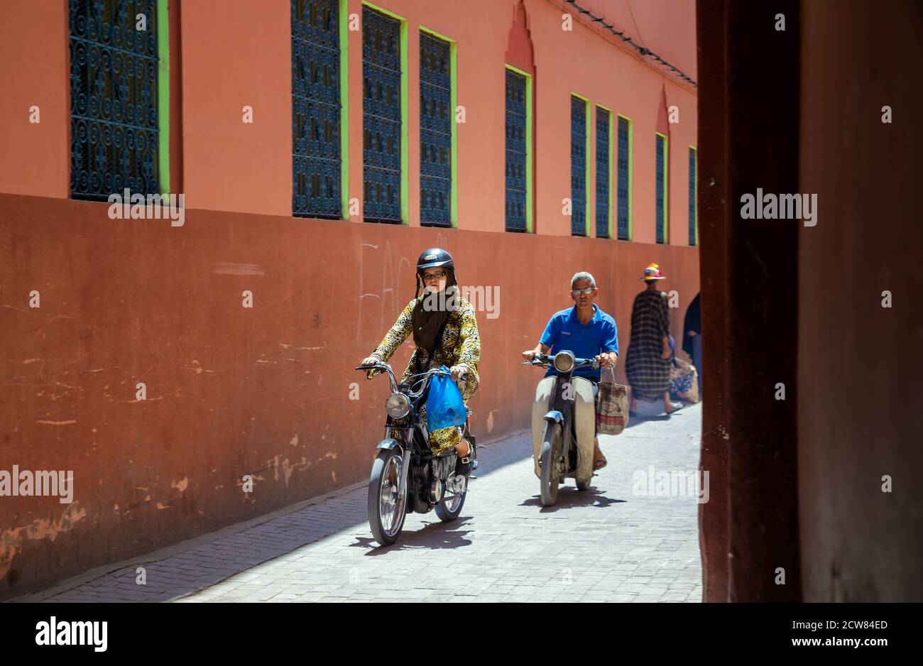 MARRAKESCH,MAROKKO,05.31.2019 Motorradfahrer auf der Straße der Altstadt von Marrakesch. Roller sind die typischen Verkehrsmittel in der Medina von Marrakesch Stockfoto