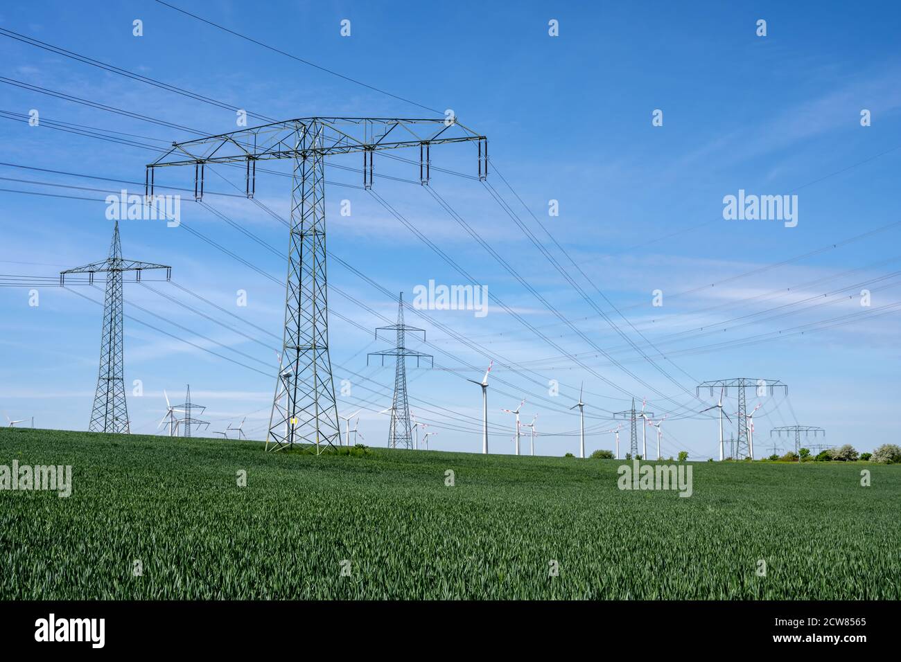 Stromleitungen mit Windturbinen im Hintergrund, in gesehen Deutschland Stockfoto