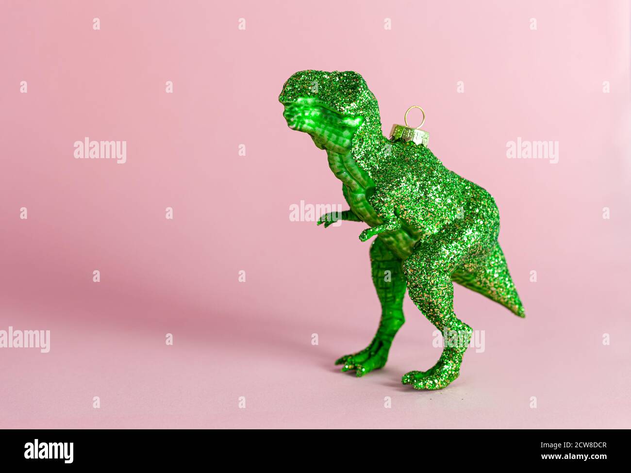 Kitschige T-Rex weihnachtsschmuck für die Feiertage, auf rosa Stockfoto