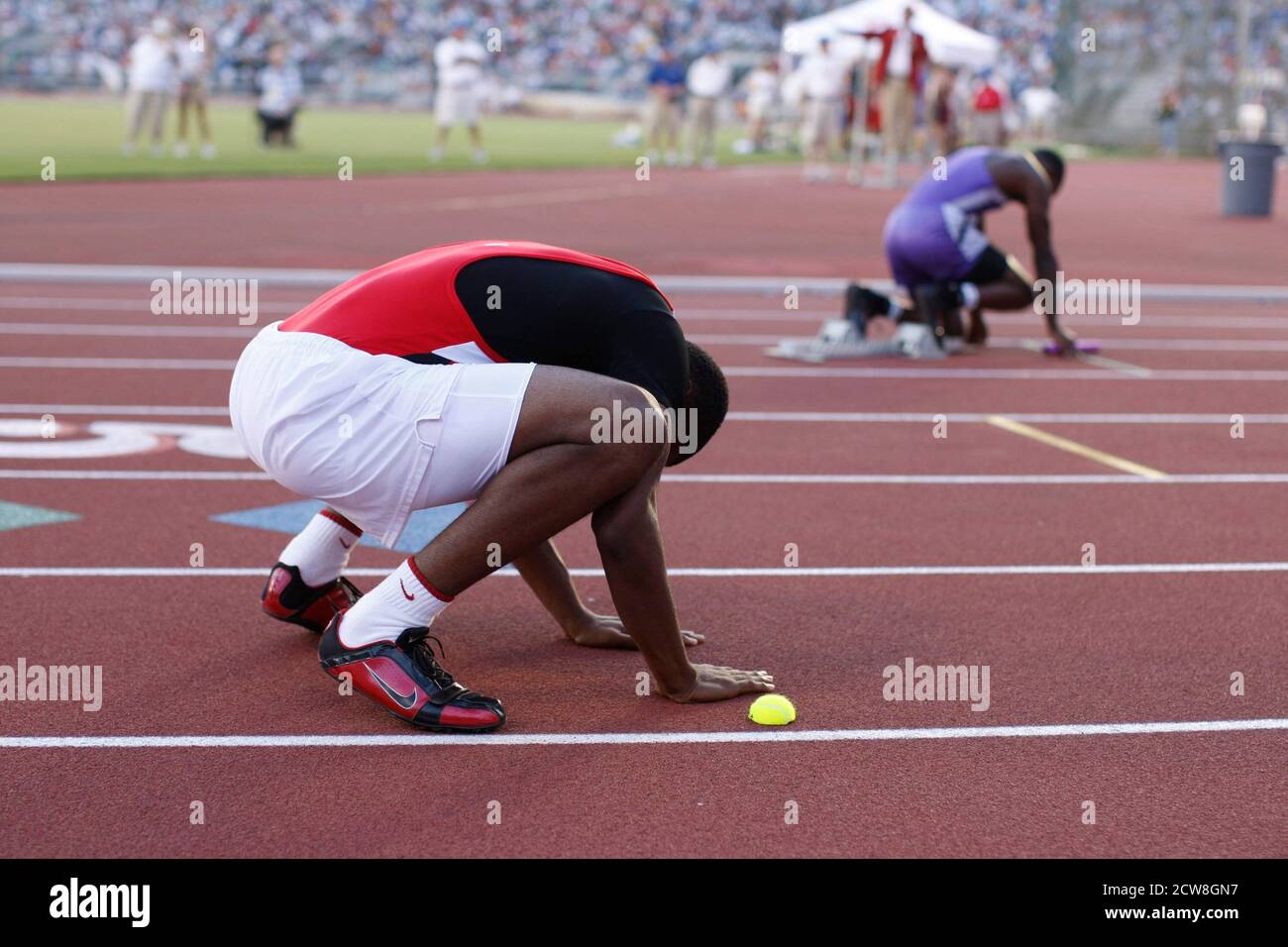 Austin, TX 10. Mai 2008: Ein afroamerikanischer Läufer streckt vor dem Start einer 400-Meter-Staffel auf der Texas High School State Championship Track Meet Action. ©Bob Daemmrich Stockfoto