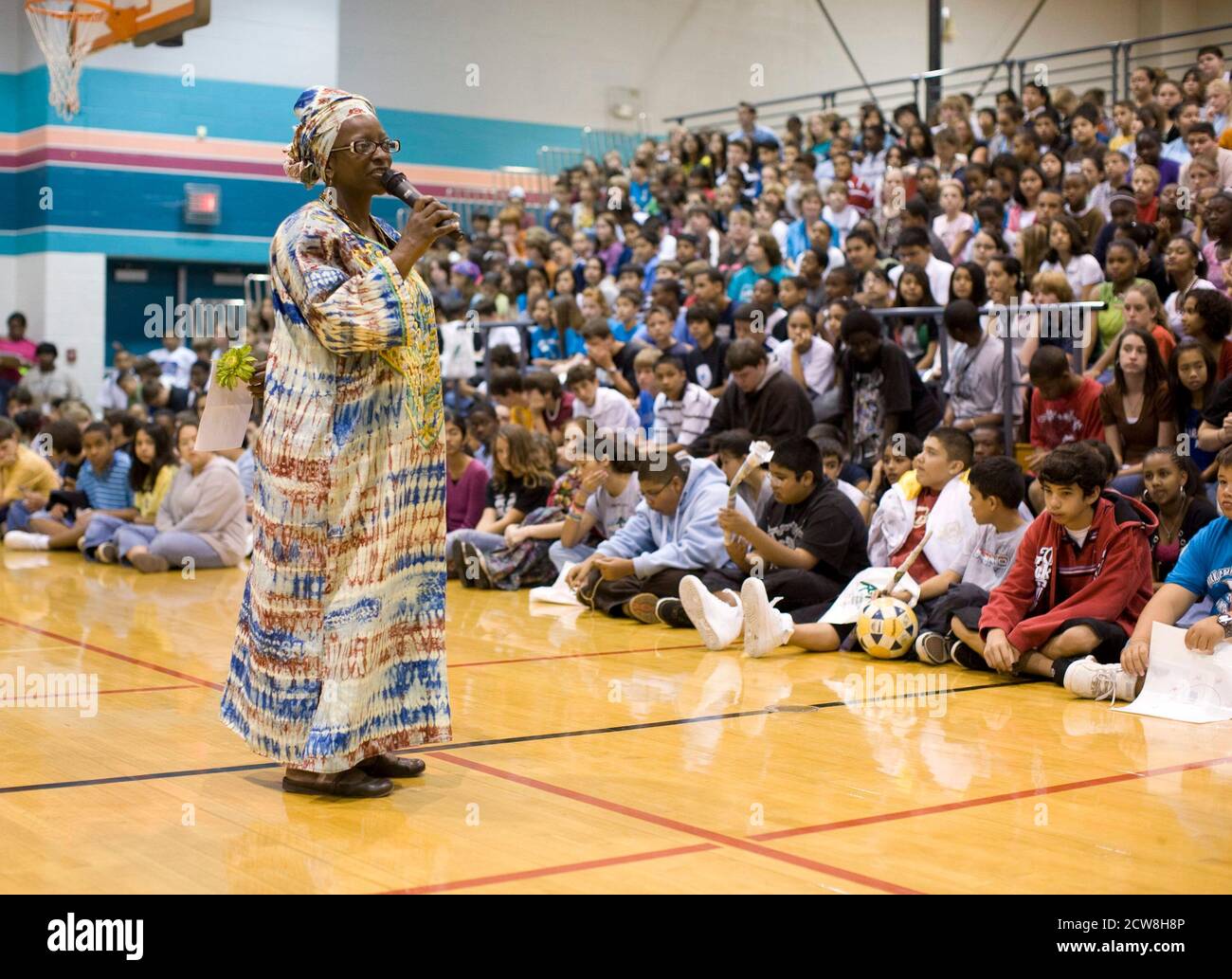 Pflugerville, TX 2. Juni 2008: Afroamerikanische Weltgeographielehrerin nigerianischer Abstammung spricht bei einer Versammlung in der Schulhalle während einer jährlichen Feier der Menschlichkeit an der Park Crest Mittelschule mit Schülern. Der "Diversity Day" umfasst ethnische Speisen, Skits, Gedichtlesungen und Musik für Schüler der sechsten bis achten Klasse. ©Bob Daemmrich Stockfoto