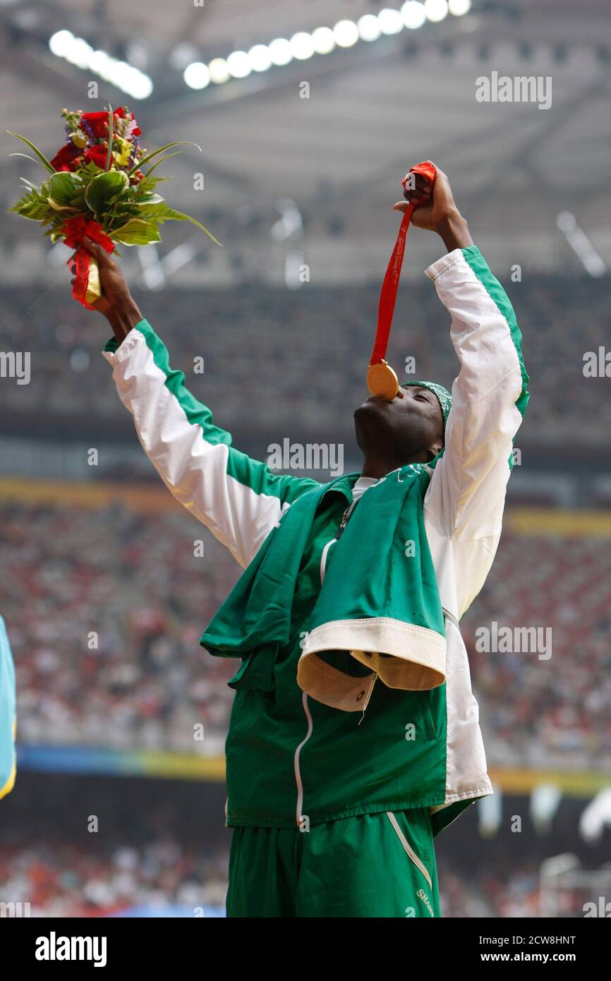 Peking, China 8. September 2008: Osama Al Shanqiti aus Saudi-Arabien gibt vor, seine Goldmedaille zu essen, nachdem er während der Paralympics in Peking den Dreisprung der Männer bei Leichtathletik-Events im Vogelnest gewonnen hat. ©Bob Daemmrich Stockfoto