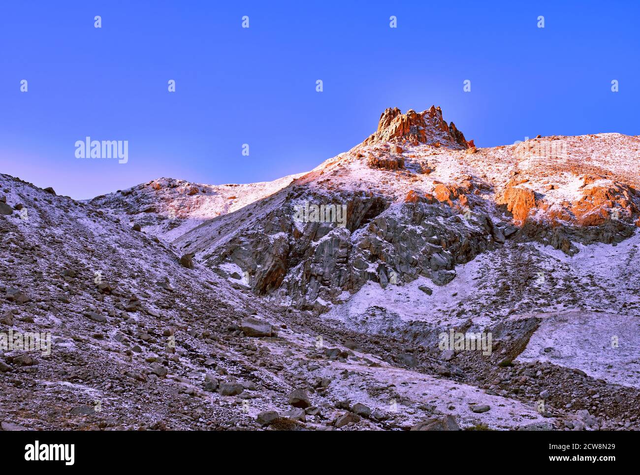 Kronenförmiger Fels mit Schnee bedeckt gegen einen blauen Himmel In den ersten Strahlen der Morgensonne Stockfoto