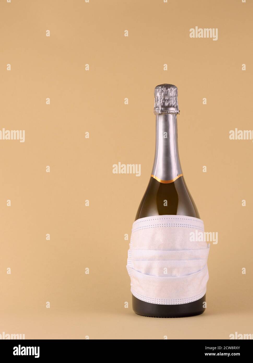 Kreatives Konzept mit Flasche und medizinischer Maske. Selbstschutzkonzept. Flasche in einer medizinischen Maske, um Viren zu schützen. Vertikale Ausrichtung mit Platz Stockfoto